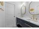 Bright bathroom featuring double sinks with gold fixtures and stylish oval mirrors at 23538 Valderama Ln, Sorrento, FL 32776