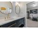 Bathroom featuring double sinks, modern fixtures, a marble countertop, and a view into the bedroom at 23538 Valderama Ln, Sorrento, FL 32776