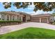 Elegant single-story home featuring a paver driveway, three-car garage, arched windows, and well-maintained landscaping at 23538 Valderama Ln, Sorrento, FL 32776