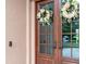Elegant front door adorned with wreaths, creating a warm and inviting entrance to the home at 23538 Valderama Ln, Sorrento, FL 32776