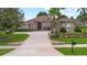 Beautiful home with a circular driveway, mature landscaping, and a well-manicured lawn at 23538 Valderama Ln, Sorrento, FL 32776