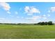 Picturesque golf course featuring lush green grass, mature trees, and sand traps under a bright blue sky at 23538 Valderama Ln, Sorrento, FL 32776