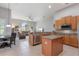 Open-concept kitchen with granite countertops, stainless steel appliances, and island, flowing into the living area at 23538 Valderama Ln, Sorrento, FL 32776
