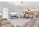 Open-concept living room featuring a kitchen with breakfast bar, comfortable seating, and modern decor at 23538 Valderama Ln, Sorrento, FL 32776