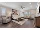 Bright main bedroom with hardwood floors, large bed, and cozy seating area at 23538 Valderama Ln, Sorrento, FL 32776