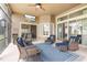 Enclosed screened patio featuring comfortable seating with a ceiling fan, and a view of the backyard at 23538 Valderama Ln, Sorrento, FL 32776