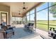 Relaxing screened porch with ceiling fans, comfortable seating, and a view of the green outdoors at 23538 Valderama Ln, Sorrento, FL 32776