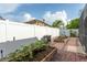 Cozy backyard featuring a brick patio, garden beds, a white fence, and outdoor grill at 2406 Blossomwood Dr, Oviedo, FL 32765