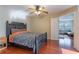 Serene bedroom featuring a comfortable bed, wood floors, a ceiling fan, and access to a connected living room at 2406 Blossomwood Dr, Oviedo, FL 32765