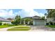 Charming one-story home with a lush green lawn, mature trees, and a two car garage at 2406 Blossomwood Dr, Oviedo, FL 32765