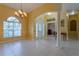 Inviting foyer featuring tile flooring, a chandelier, large windows, and a decorative front door at 2406 Blossomwood Dr, Oviedo, FL 32765