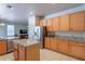 Modern kitchen with stainless steel refrigerator, granite countertops, and a view into the living room at 2406 Blossomwood Dr, Oviedo, FL 32765