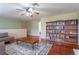 Open-concept living room featuring a ceiling fan, wood floors, a bookshelf, and a neutral color palette at 2406 Blossomwood Dr, Oviedo, FL 32765