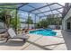 Inviting screened-in pool area with clear blue water, lounge chair, and surrounding patio space at 2406 Blossomwood Dr, Oviedo, FL 32765