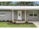 Charming single-story home featuring a covered porch and a white front door with decorative glass at 255 Belinda Dr, Deland, FL 32720