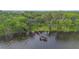 Aerial view of a waterfront property with private dock surrounded by lush greenery at 2652 Lake Howell Ln, Winter Park, FL 32792