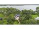 Stunning aerial view of a lakeside home surrounded by lush greenery and mature trees at 2652 Lake Howell Ln, Winter Park, FL 32792