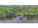 Aerial view of a waterfront property with private dock surrounded by lush greenery at 2652 Lake Howell Ln, Winter Park, FL 32792