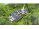 Aerial view showcasing a spacious home with a large outdoor deck, lush landscaping, and a long driveway at 2652 Lake Howell Ln, Winter Park, FL 32792