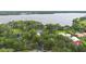 Aerial view of wooded property with lake views and a large home at 2652 Lake Howell Ln, Winter Park, FL 32792