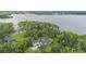 Stunning aerial view of a lakeside home surrounded by lush greenery and mature trees at 2652 Lake Howell Ln, Winter Park, FL 32792
