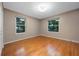 Empty bedroom with hardwood floors and two windows providing natural light at 2652 Lake Howell Ln, Winter Park, FL 32792