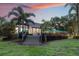 Backyard with a deck and steps leading to the lawn, surrounded by palm trees at 2652 Lake Howell Ln, Winter Park, FL 32792