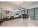 Well-lit garage with epoxy floor, white sports car, and ample storage space at 2652 Lake Howell Ln, Winter Park, FL 32792