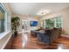 Inviting living room with hardwood floors, a comfortable sectional, and serene views of the outdoor landscape at 2652 Lake Howell Ln, Winter Park, FL 32792