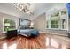Spacious main bedroom with hardwood floors, a unique light fixture, and an abundance of natural light at 2652 Lake Howell Ln, Winter Park, FL 32792