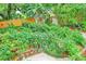 Lush backyard featuring vibrant landscaping, a privacy fence, stone pavers, and an outdoor storage shed at 2910 Hargill Dr, Orlando, FL 32806