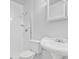 Compact white tiled bathroom featuring toilet, shower, and pedestal sink with classic fixtures at 2910 Hargill Dr, Orlando, FL 32806