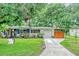 Charming single-story home with a well-manicured lawn, mature trees, and a paved walkway at 2910 Hargill Dr, Orlando, FL 32806
