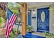 Close-up of front porch featuring blue door, American flag, and decorative plants at 2910 Hargill Dr, Orlando, FL 32806