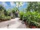 Charming home with lush tropical landscaping and a brick walkway leading to the front door at 2910 Hargill Dr, Orlando, FL 32806