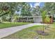 Charming single-story home featuring a well-manicured lawn, complemented by mature trees and a concrete driveway at 2910 Hargill Dr, Orlando, FL 32806
