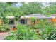 Lush front yard with a variety of plants, trees, and a well-manicured lawn leading to the home at 2910 Hargill Dr, Orlando, FL 32806