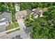 Aerial view of a tan two-story home with well manicured lawn in a neighborhood with mature trees at 2971 Cayman Way, Orlando, FL 32812