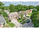 Aerial view of a tan two-story home with well manicured lawn in a neighborhood with mature trees at 2971 Cayman Way, Orlando, FL 32812