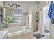 Main bathroom with a soaking tub, separate shower, and a large window providing natural light at 2971 Cayman Way, Orlando, FL 32812