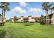 Expansive backyard with lush greenery and a building in the background surrounded by trees at 3012 S Semoran Blvd # S, Orlando, FL 32822
