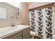Cozy bathroom with a gray vanity, shower with floral curtain, and a large, bright mirror at 3012 S Semoran Blvd # S, Orlando, FL 32822