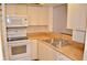 Well-lit kitchen featuring sleek white appliances, ample cabinetry, and a stainless steel sink at 3012 S Semoran Blvd # S, Orlando, FL 32822