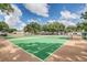 Well-maintained community tennis court surrounded by lush trees and blue skies at 3012 S Semoran Blvd # S, Orlando, FL 32822