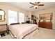 Spacious bedroom features carpet, ceiling fan, three windows with blinds, and dark wood furniture at 312 Trieste Loop, Lake Mary, FL 32746