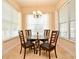 Cozy dining space featuring a glass-top table, four chairs, a chandelier and natural light from three windows at 312 Trieste Loop, Lake Mary, FL 32746