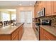 Well-equipped kitchen featuring granite countertops, stainless appliances, and seamless access to dining area at 312 Trieste Loop, Lake Mary, FL 32746