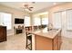 Well-lit kitchen with granite countertops, stainless sink, and barstool seating open to the dining and living area at 312 Trieste Loop, Lake Mary, FL 32746