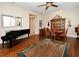 Bright living space with hardwood floors, a piano, and seamless transition to the dining area at 312 Trieste Loop, Lake Mary, FL 32746