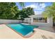Refreshing swimming pool with brick trim, set against a backdrop of lush greenery and a sunny sky at 3251 Wickersham Ct, Orlando, FL 32806